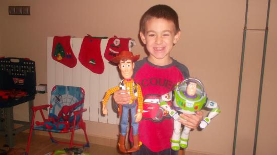 Un niño de Lopera muestra sus juguetes comprados para estas Navidades.